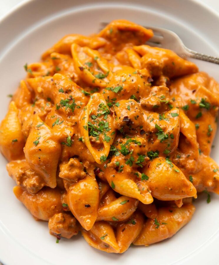 close up shot of creamy beef shells in large white dish with silver fork