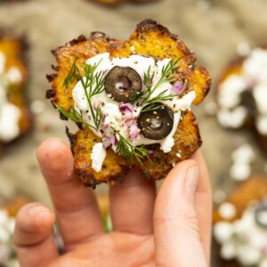 close up overhead shot of hand holding Greek smashed potato