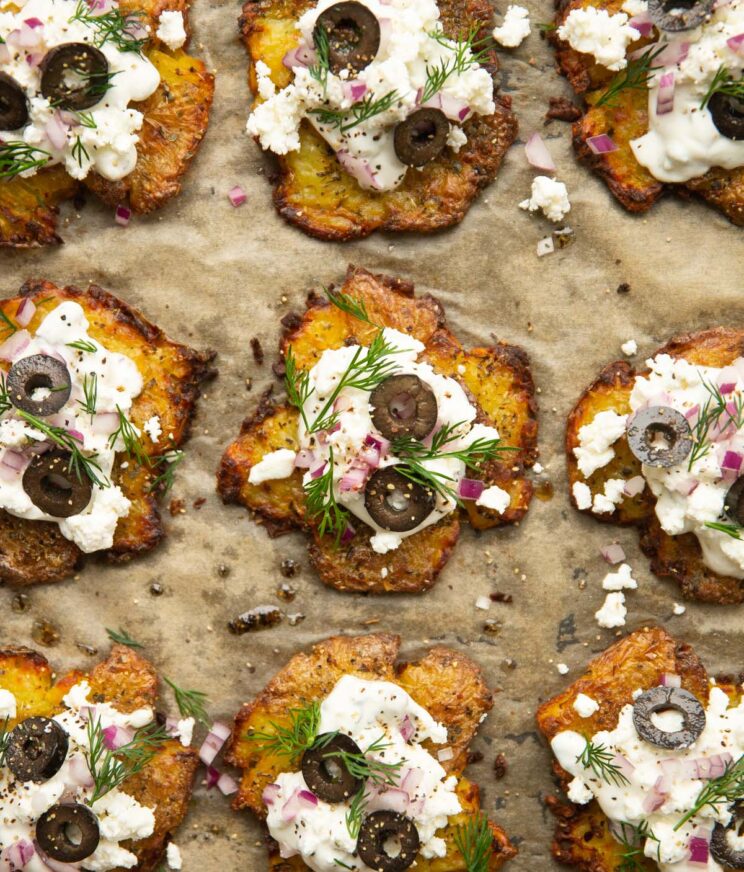 overhead shot of Greek style smashed potatoes on baking tray