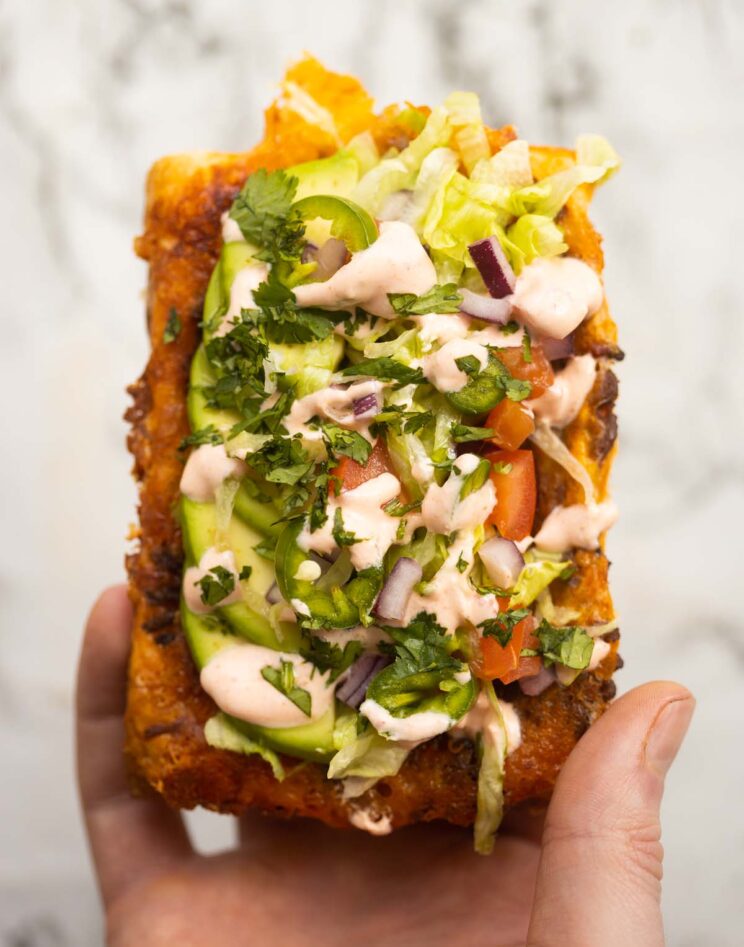 close up overhead shot of hand holding puff pastry taco