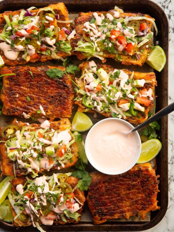 overhead shot of puff pastry tacos on large tray with small pot of taco sauce