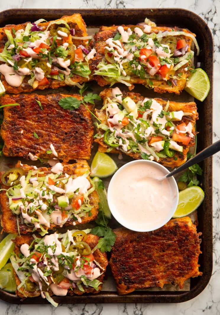 overhead shot of puff pastry tacos on large tray with small pot of taco sauce