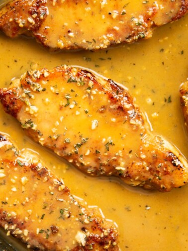 close up of rosemary garlic butter pork chop in pan