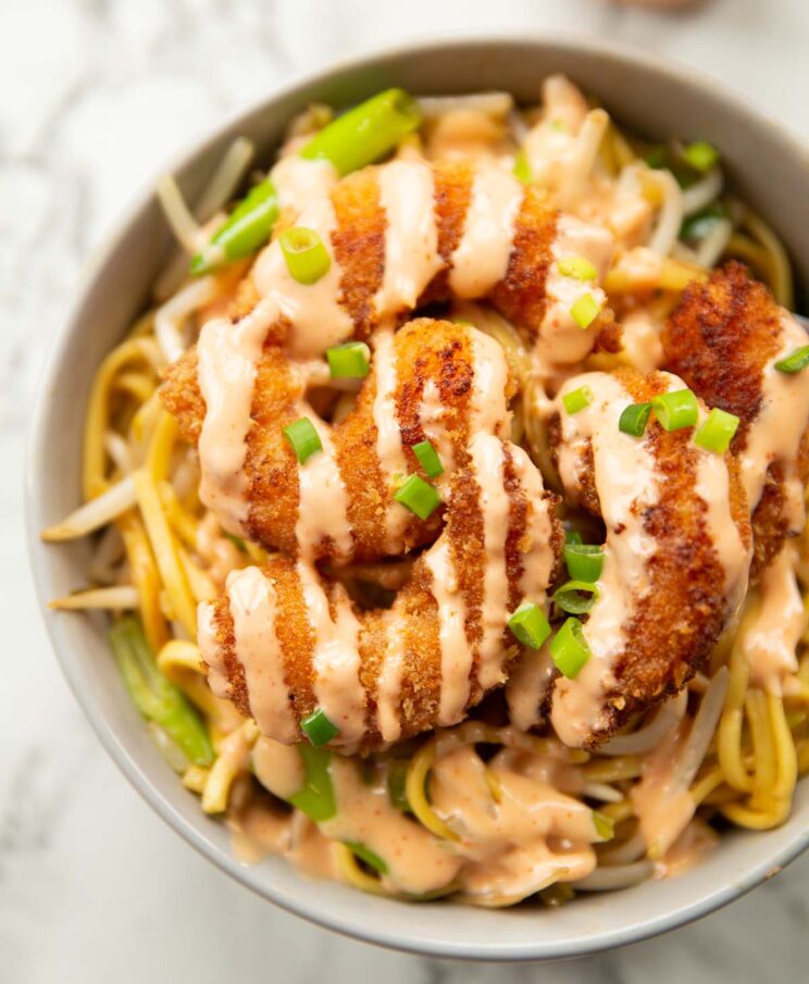 close up overhead shot of bang bang shrimp noodles in large grey bowl