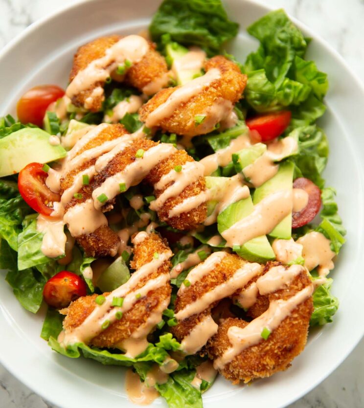 close up overhead shot of bang bang shrimp salad in large white bowl