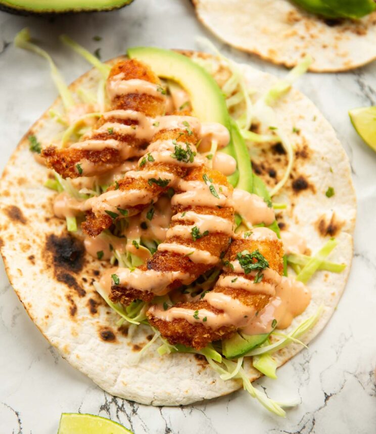 overhead shot of open bang bang shrimp taco on marble backdrop