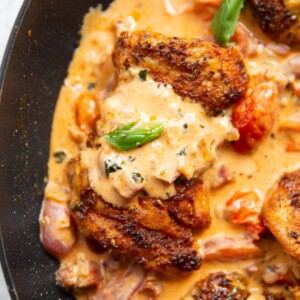 close up overhead shot of chicken thigh in creamy chorizo sauce in large pan