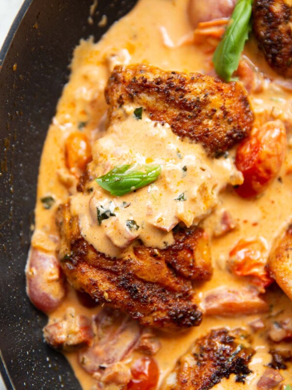 close up overhead shot of chicken thigh in creamy chorizo sauce in large pan