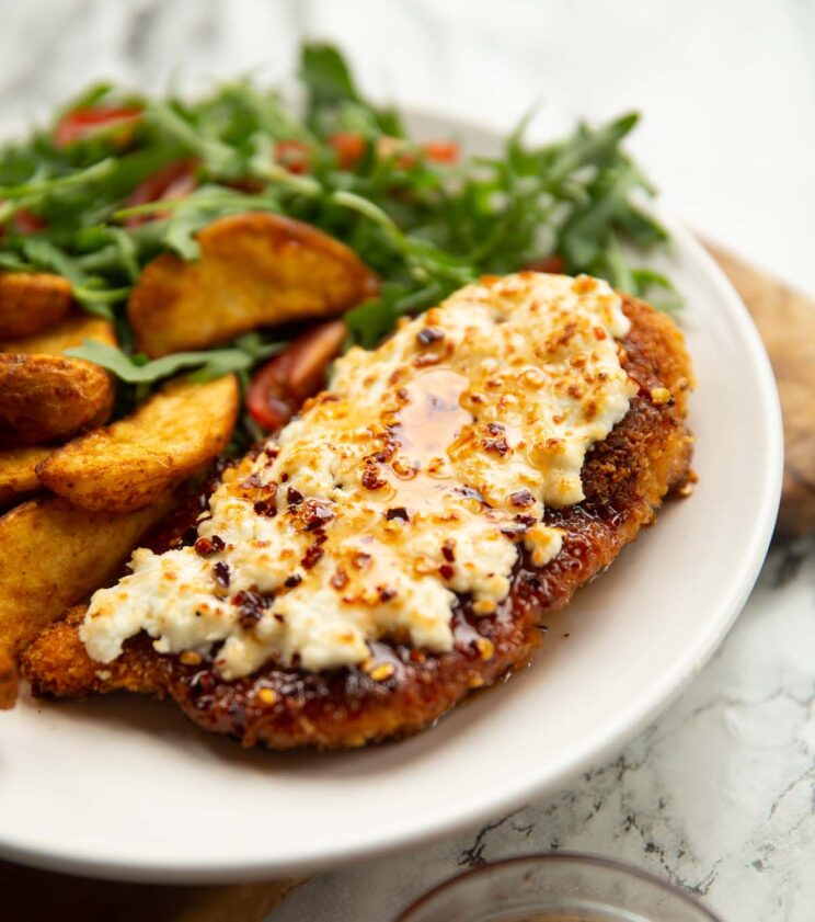 hot honey feta chicken served on small white plate with wedges and rocket