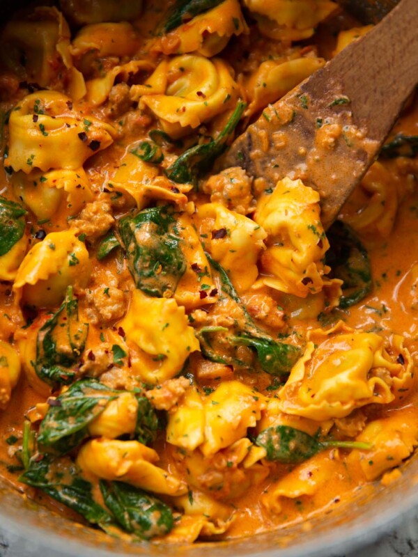 sausage tortellini in large pot with wooden spoon digging in