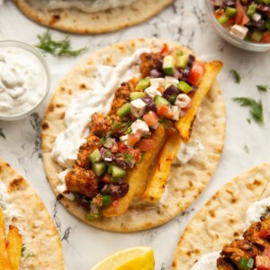 overhead shot of unfolded chicken souvlaki on marble backdrop