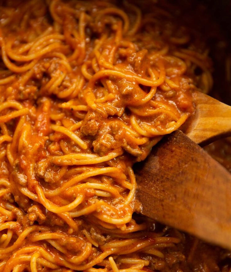 close up shot of taco spaghetti in large pot with wooden spoon