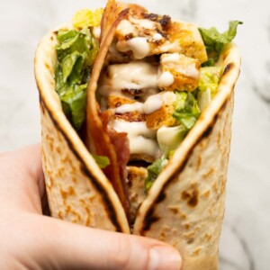 close up overhead shot of hand holding caesar chicken flatbreads