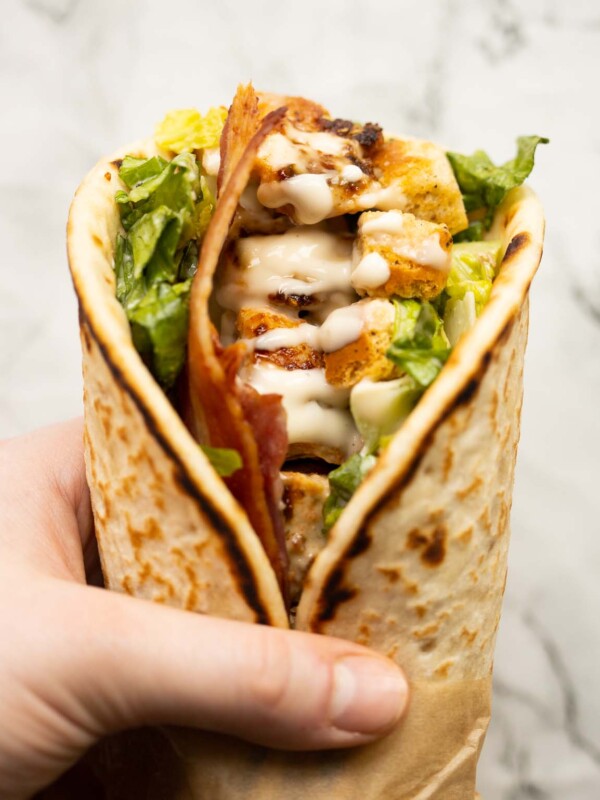 close up overhead shot of hand holding caesar chicken flatbreads