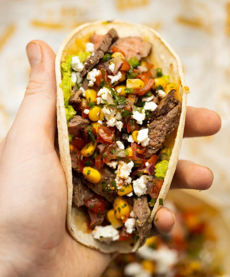 close up overhead shot of hand holding steak taco