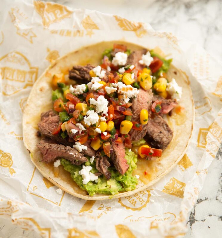 close up shot of steak taco on scrunched up paper