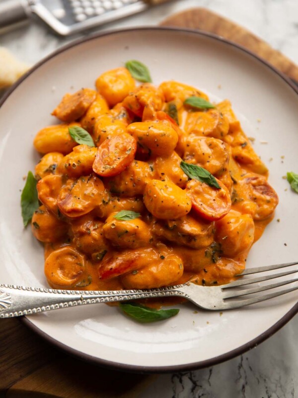 creamy gnocchi chorizo on small white plate with silver fork