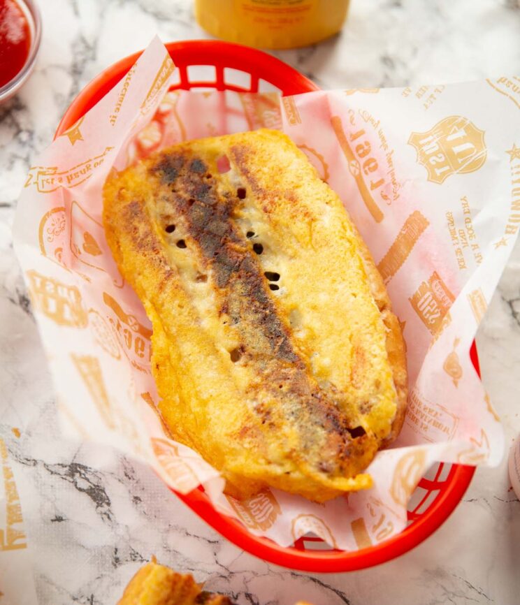 hot dog grilled cheese on red basket on marble background