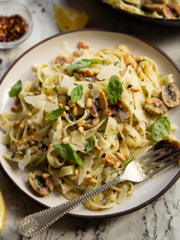 olive pasta served on small white plate with silver fork