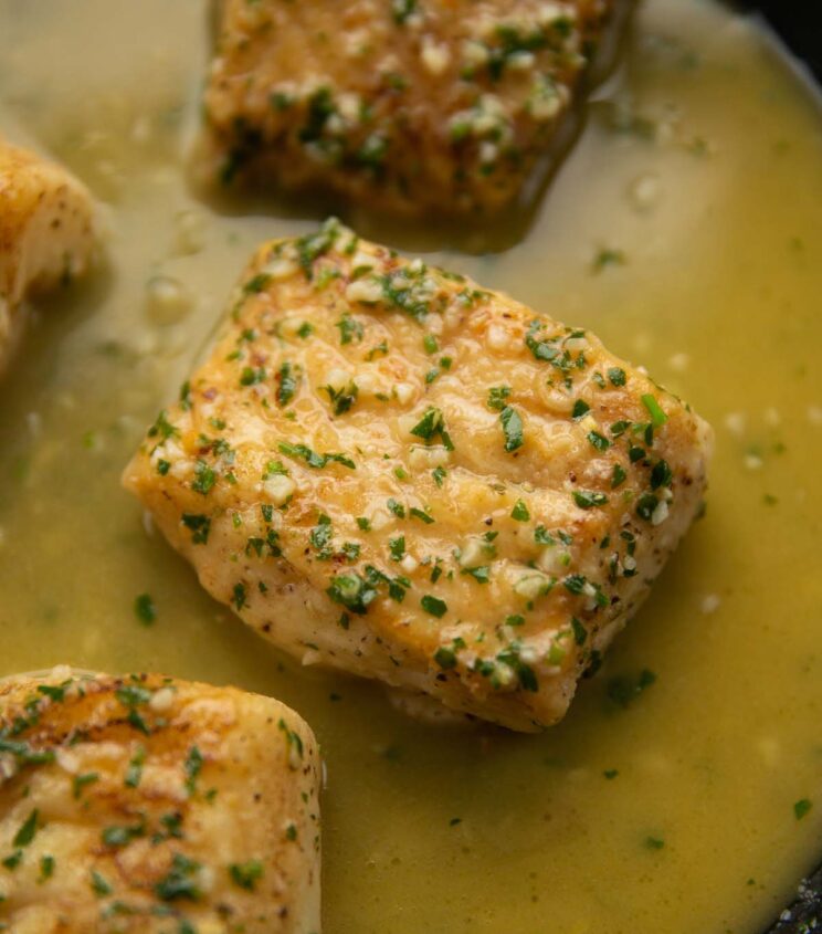 close up shot of garlic butter cod in pan