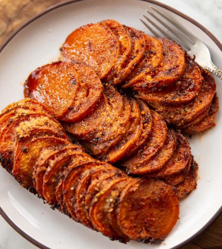 cajun butter sweet potatoes on small white plate with silver fork