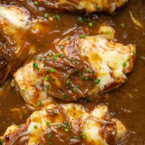 close up overhead shot of french onion chicken in pan garnished with chives