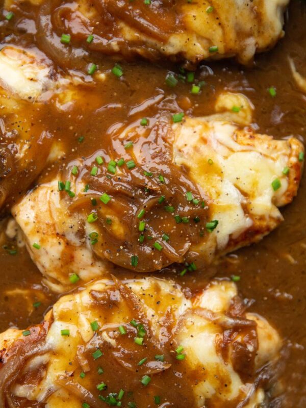 close up overhead shot of french onion chicken in pan garnished with chives