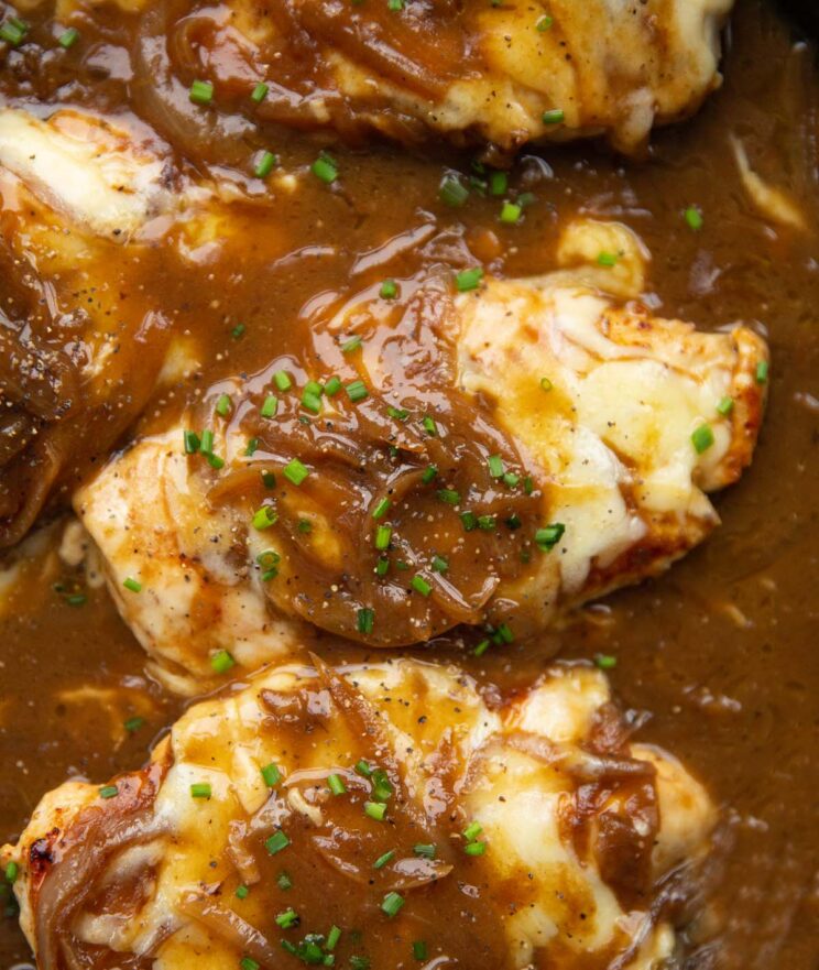 close up overhead shot of french onion chicken in pan garnished with chives