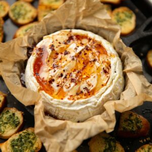 hot honey baked camembert on baking tray with bagel chips