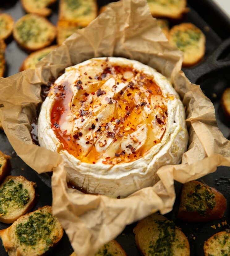 hot honey baked camembert on baking tray with bagel chips