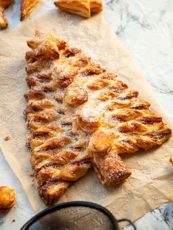 puff pastry Christmas tree on brown baking paper dusted with parmesan