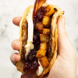 close up overhead shot of hand holding smash sausage taco