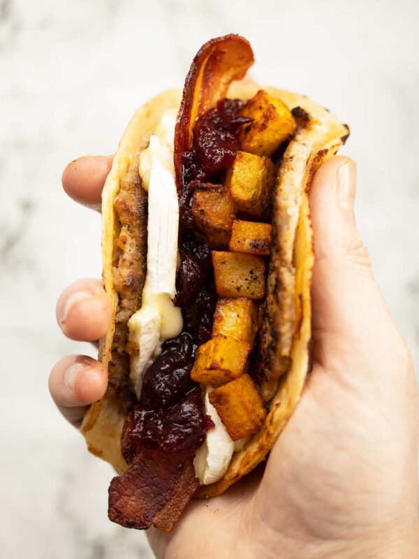 close up overhead shot of hand holding smash sausage taco