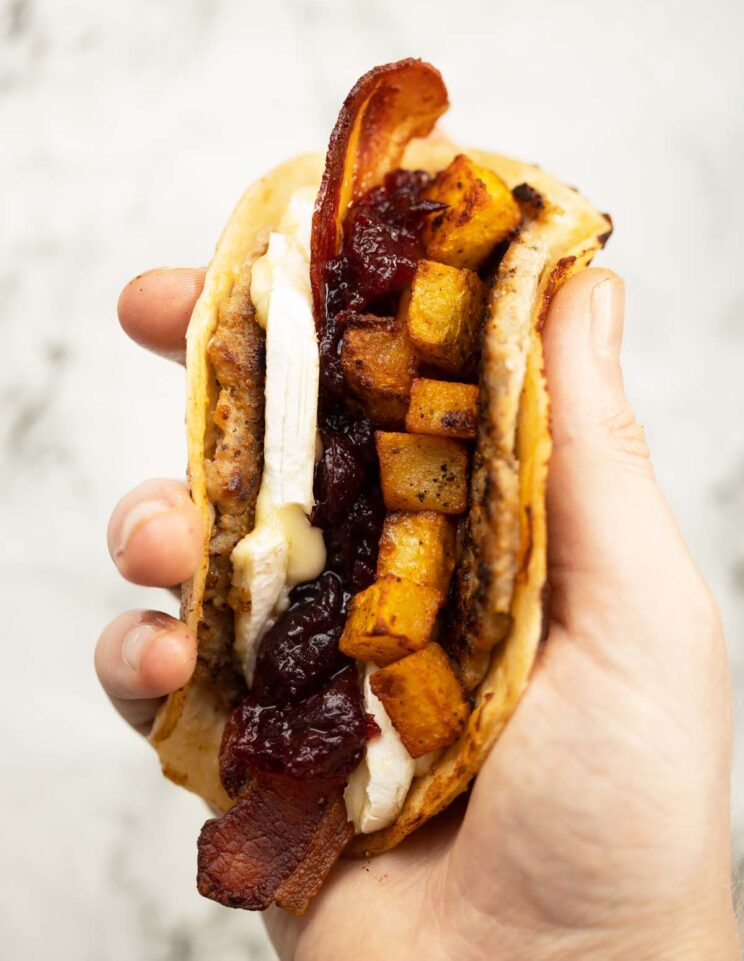 close up overhead shot of hand holding smash sausage taco