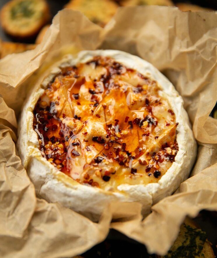 close up shot of spicy baked camembert in baking paper