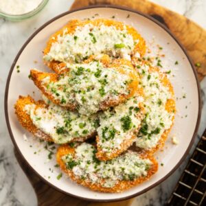 garlic parmesan chicken tenders on small white plate on wooden board