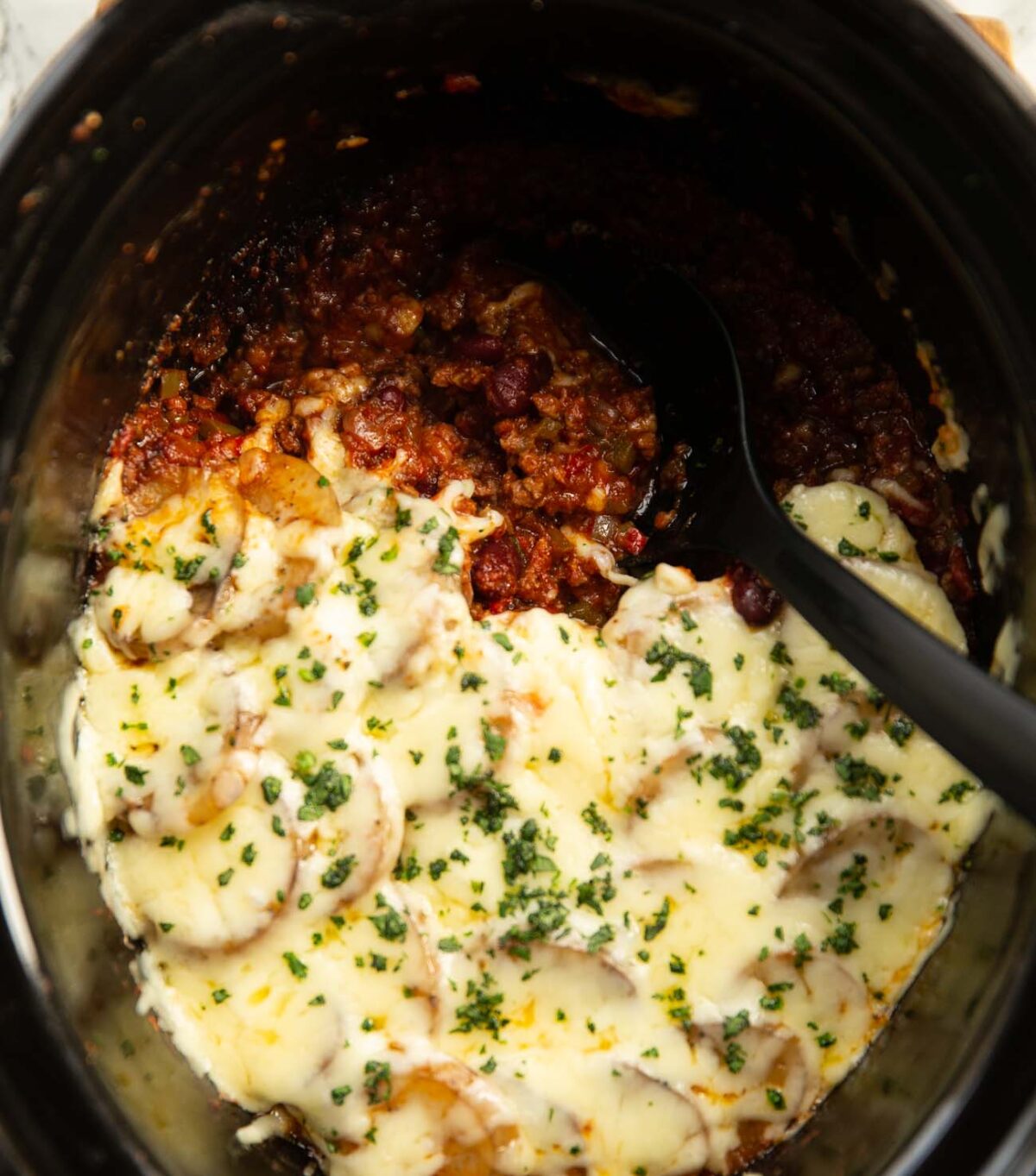 overhead shot of slow cooker cajun beef hotpot with serving spoon digging in