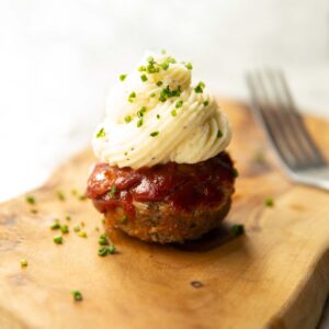 meatloaf cupcake on wooden chopping board garnished with chives