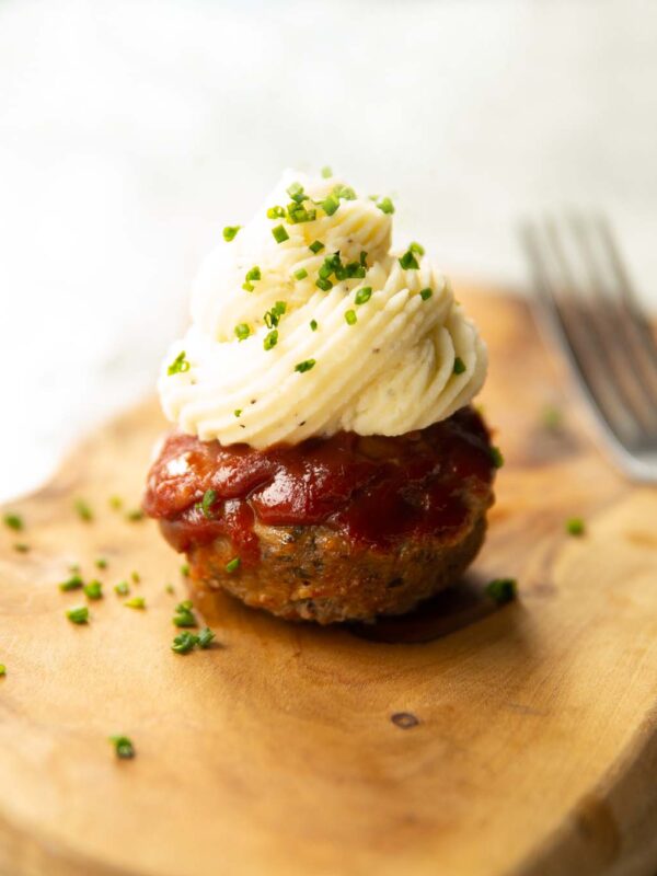 meatloaf cupcake on wooden chopping board garnished with chives